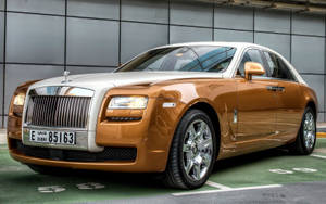 金色勞斯萊斯 Ghost 停放在現代車庫中，帶有杜拜車牌。
