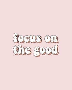 在柔和粉紅色背景上以粗體3D風格文字呈現的勵志名言 focus on the good — 天空美學 壁紙