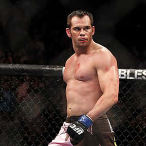 一名血跡斑斑的MMA戰士在比賽後站在八角籠內。