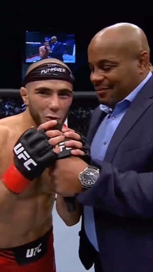 UFC拳手在比賽後被一名微笑的西裝男擁抱。