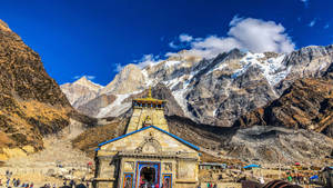一座色彩繽紛的寺廟，坐落在山谷中，背景是白雪覆蓋的山峰。 — 廟宇 壁紙
