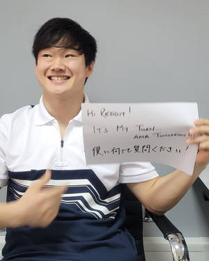 年輕男子微笑著手持標語邀請Reddit提問。