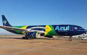 帶有巴西國旗塗裝的Azul Airlines飛機停在強烈陽光下的機場停機坪。
