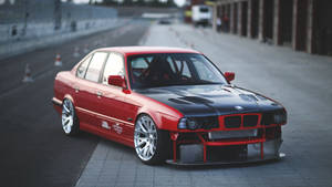 改裝嘅紅色同黑色BMW房車停泊喺賽車場上。