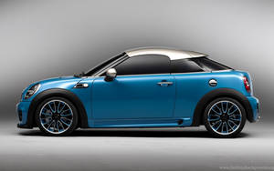 藍色MINI Cooper，銀色車頂和黑色飾邊，在工作室環境中。