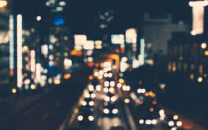 夜晚的城市景觀，帶有汽車和建築物的模糊燈光。 — 夜晚 GIF 壁紙