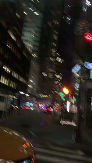 夜間城市街道，帶有模糊燈光和高樓大廈。