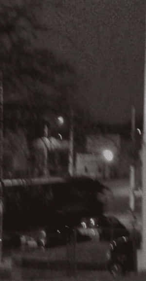 模糊的夜晚街道，有汽車和遠處燈光。