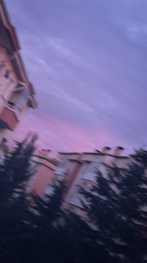 暮色天空下的住宅樓宇和樹木，帶有動態模糊效果。