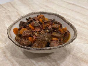 一碗豐盛的肉和紅蘿蔔燉菜放在大理石表面上。 — 美食 壁紙