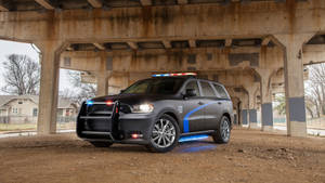 警用SUV閃爍著燈光停泊在混凝土高架橋下。 — 汽車 壁紙
