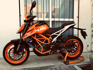 橙色和黑色的KTM 390 Duke電單車停泊在瓷磚庭院上。 — 機車 壁紙