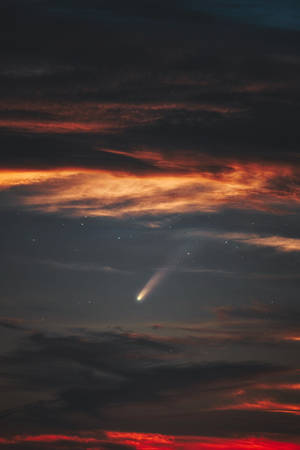 一顆彗星在色彩繽紛的暮色天空中滑行，伴有星星和雲彩。 — 夜空 壁紙