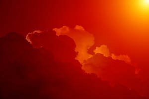 夕陽下明亮的太陽照亮了火紅和橙色的雲朵。 — 唯美雲朵動態 壁紙