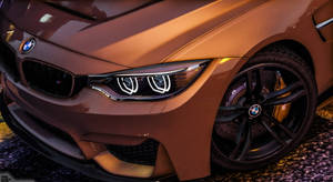 光澤青銅色BMW M4跑車，帶有發光的頭燈和黑色車輪。