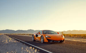 日落時沙漠高速公路上的橙色McLaren