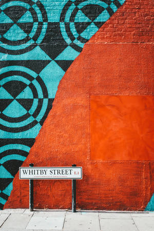 Whitby Street 標誌旁磚牆上的彩色幾何壁畫