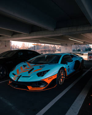 一輛青色和橙色的林寶堅尼Aventador，在黃昏時停泊在城市高架橋下。