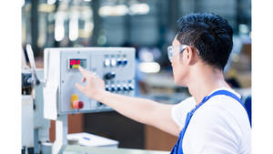 技術人員在工廠操作工業機器控制面板
