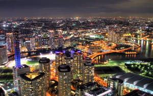 夜間航拍，現代城市燈火通明，河流和橋樑清晰可見。 — 城市景觀 壁紙