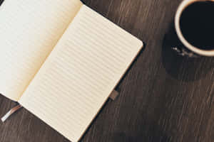 木桌上打開的筆記本和咖啡杯，適合書寫或寫日記。