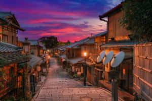 黃昏時分一條寧靜的日本街道，有傳統建築和溫暖的燈籠。 — 日本 壁紙