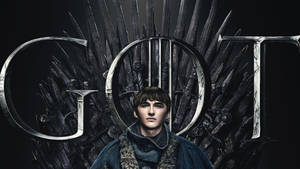 穿著毛皮襯裡斗篷的年輕男子坐在鐵王座上，背後有「GOT」字母。