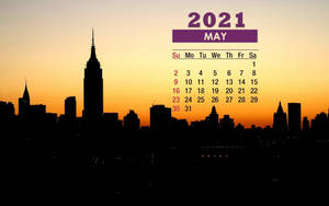 2021年5月日曆，帶有日落時分的城市天際線剪影。
