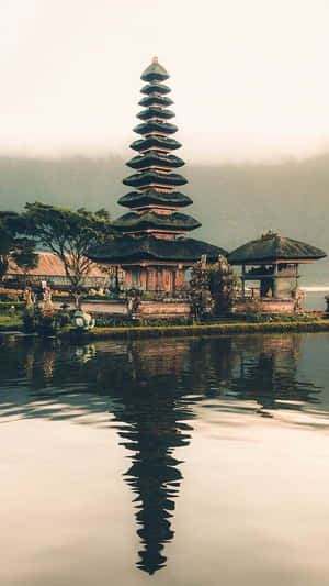 峇里島寺廟倒映在靜止的水面上，背景迷濛 — 唐人街 GIF 壁紙