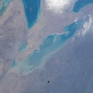 衛星視角下切割乾旱陸地的碧綠海灣，可見水流。