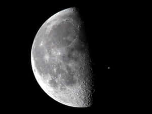 在黑暗的星空中，可見隕石坑的半個月亮。