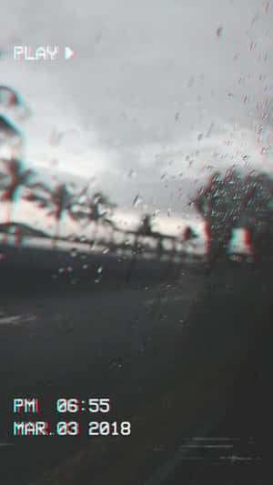 暮色中棕櫚樹成蔭的街道，透過雨痕斑駁的車窗看到的故障風格景象。