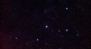 繁星點點的夜空，有發光的星星和微弱的紅色星雲。