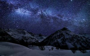 白雪覆蓋的山脈在充滿活力的星空下，銀河系清晰可見。