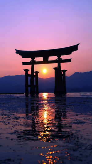 夕陽下鳥居在水中的倒影，背景有山 — 簡約藍色美學 壁紙