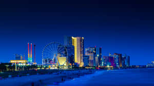 夜間海濱，摩天輪亮起，城市天際線。 — 2560x1440 壁紙