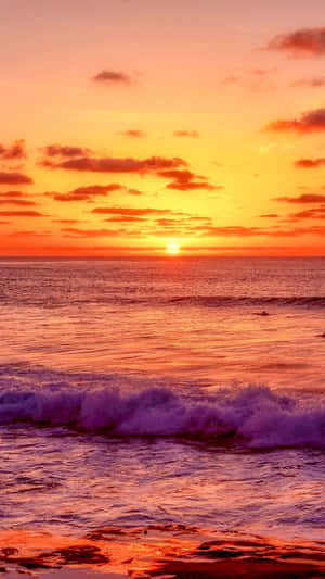 夕陽下的海洋，天空色彩繽紛，海浪拍打沙灘