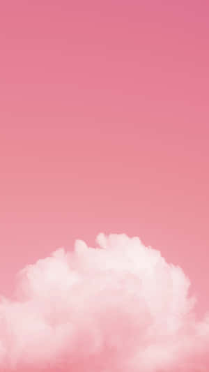一朵蓬鬆的雲漂浮在柔和的粉紅色天空中。