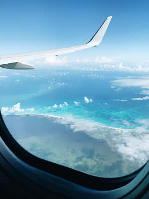 從飛機窗戶看到的飛機機翼，在碧綠海洋和雲朵之上。 — 天空景觀 壁紙