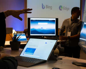 科技演講者在會議上向顯示 Bing 和 Edge 的筆記型電腦做手勢。