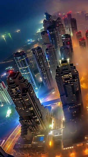 霧氣瀰漫的夜間城市景觀，燈火通明的摩天大樓和發光的街道。