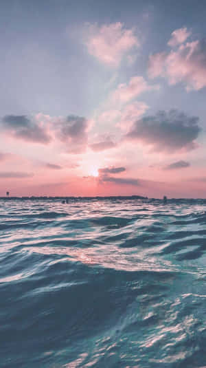 夕陽下的海浪與粉紅和藍色的天空