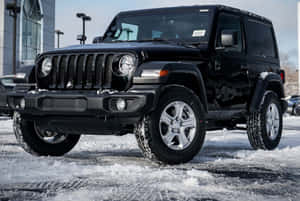 冬季停在雪地上的黑色Jeep Wrangler。