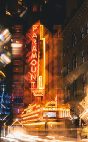 夜晚發光的 Paramount 劇院標誌，帶有移動汽車的光跡。
