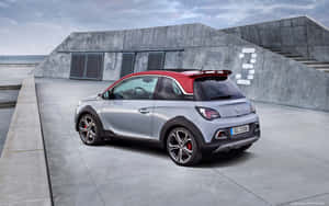 銀色和紅色Opel Adam停泊在海洋附近的混凝土碼頭上