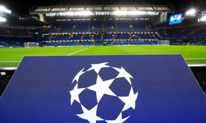 夜晚空足球場前藍色板上的UEFA歐聯標誌