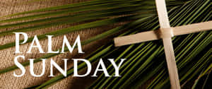 木製十字架在棕櫚葉上，粗麻布上有「Palm Sunday」文字。 — 交叉 壁紙