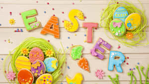 復活節曲奇拼出單詞 Easter，並配有裝飾雞蛋和花朵。 — 16:9 壁紙