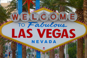 歡迎來到 Fabulous Las Vegas Nevada 標誌，背景有棕櫚樹和城市交通。