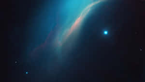 深空中鮮豔的青綠色和粉紅色星雲，帶有明亮的藍色星星。